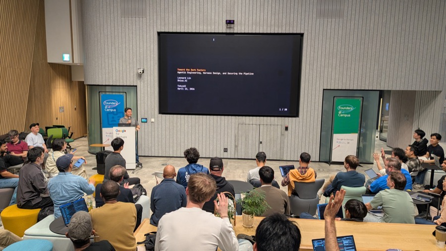 Leonard Lin presenting Toward the Dark Factory at Tokyo AI, audience engaged with hands raised